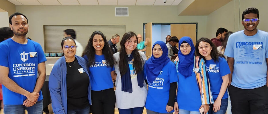A group of international students pose for a photo during a community event in the Luptak Terrace Room.